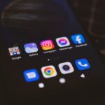 A smartphone displaying popular social media apps in a dimly lit environment, perfect for tech and communication themes.
